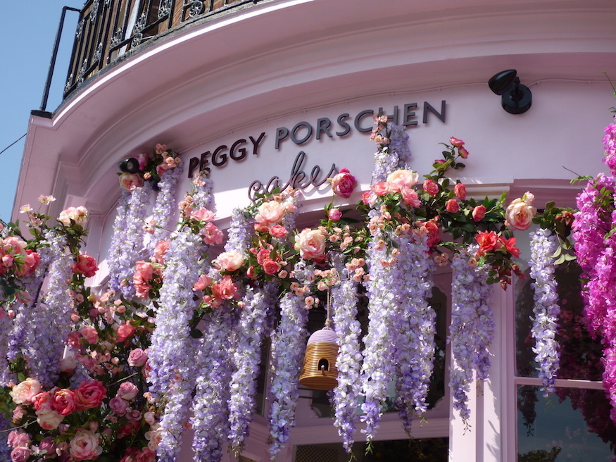 The Peggy Porshcen sign - pale pink with brown lettering - with fake pink and lilac flowers dripping off it.