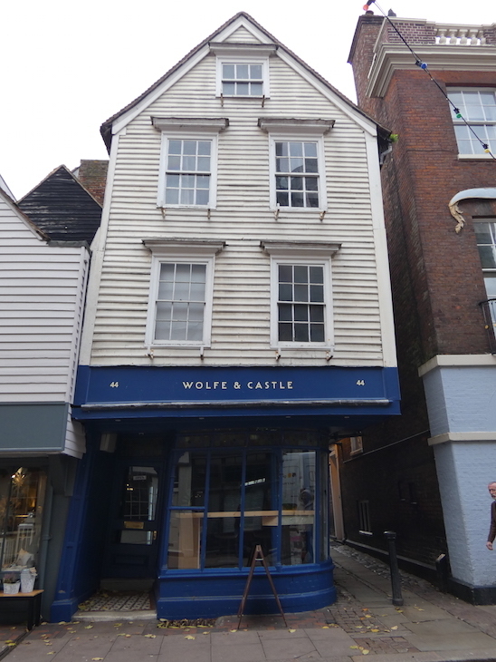 The front of a white, weatherboarded building which leans to the right