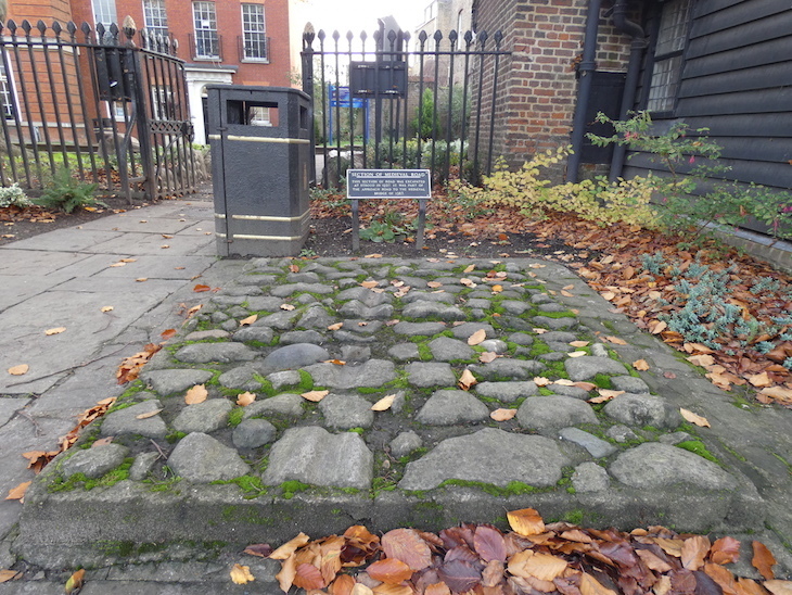 A section of stone paving, with a sign explaining that it's part of the Medieval road which was excavated in Strood and put on display in Eastgate Gardens