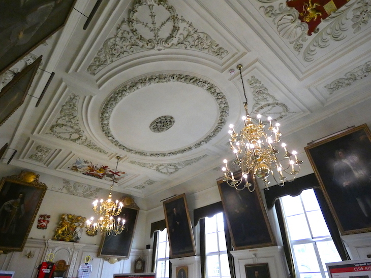 The interior of the Guildhall - embossed, painting ceilings with two chandeliers lighting the room