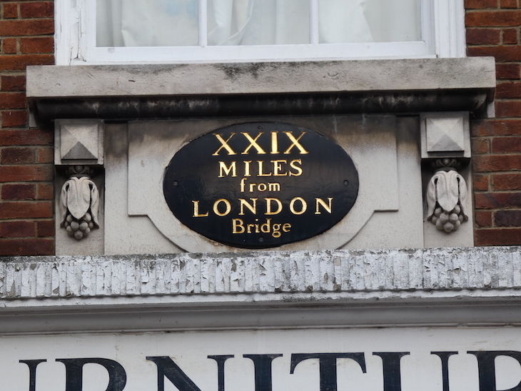 A black and gold plaque reading "XXIX Miles from London Bridge" mounted on the wall of a building in Rochester High Street