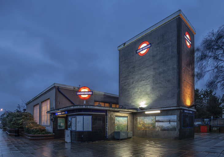 An ominous, bunker-esque tube station - grey and looming, but punctuated with glowing roundels