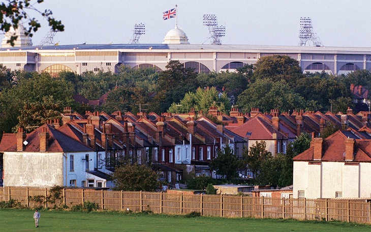 The old Wembley stadium rises above red roofed terrace houses
