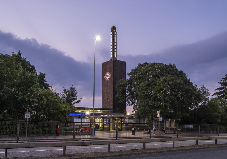 A modernist station with a tall tower, and a roundel on it