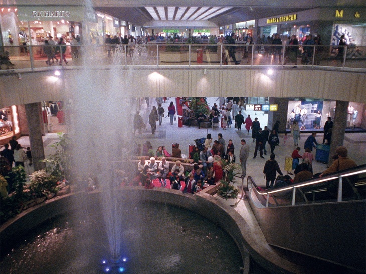 A fountain spurts out from a pond inside a shopping centre