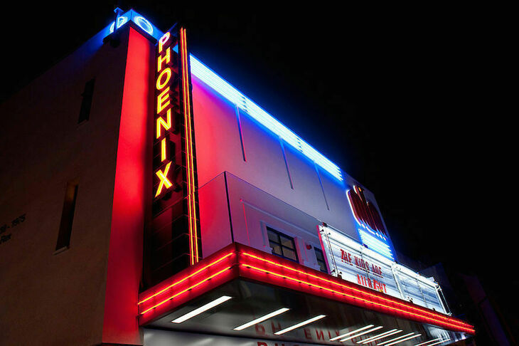 Frontage of the Phoenix Cinema, lit up in neon