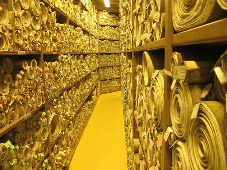 Lots of yellow scrolls on shelves at westminster's parliamentary archives