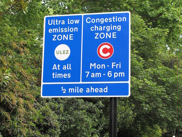 Blue road signs warning drivers that the ULEZ and Congestion Charge Zones start in 1/2 mile