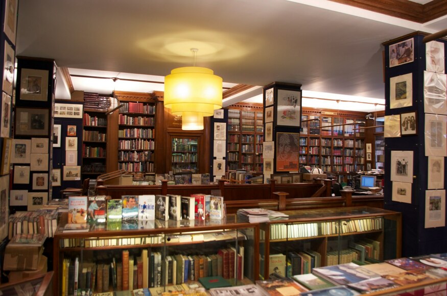 An antique bookshop packed with tomes, and old prints on the wall