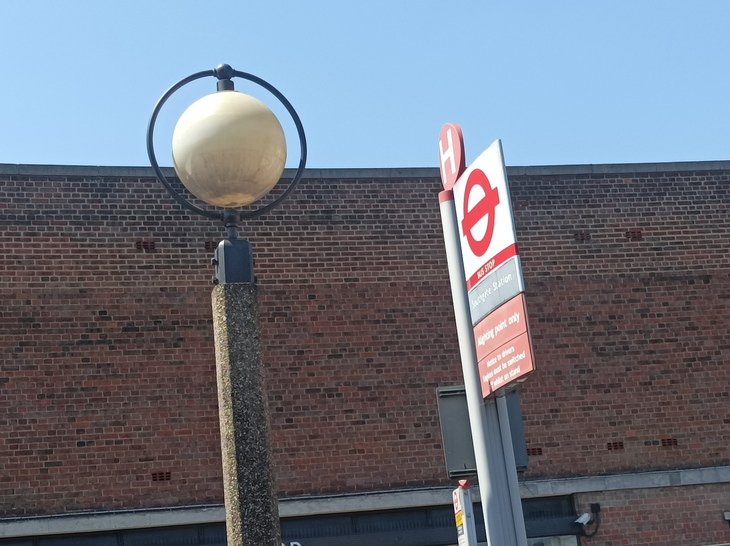 A globular lamp next to a bus stop