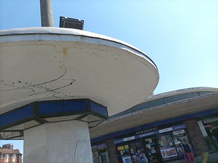 A curvaceous bus shelter in front of the station