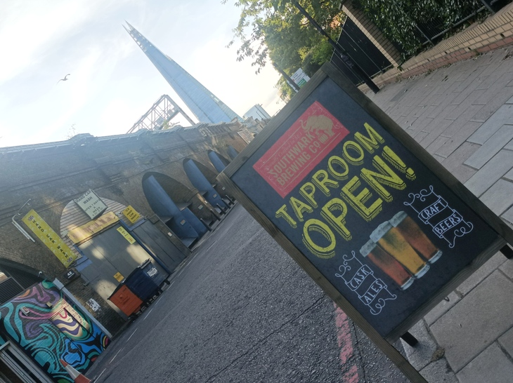 Brewery taprooms in London: A sign saying tap room open - with the Shard in the distance