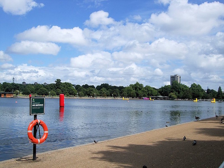 Looking across the Serpentine in Hyde Park, with some row boats on the lake in the distance