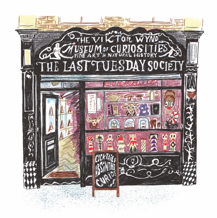 A black shopfront with ornate white writing: The Last Tuesday Society. Various oddities are displayed in the window