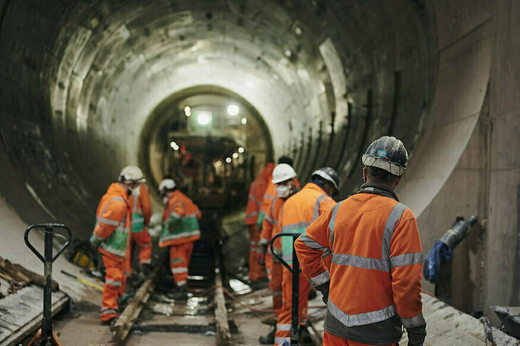 Workers in orange high vis in a tunnel