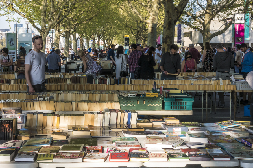 People peruse books beneath Waterloo Bridge