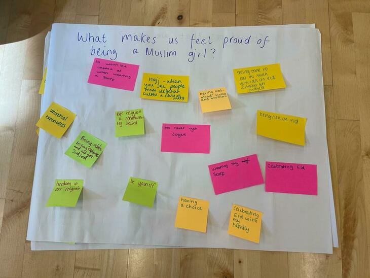 A set of luminous post it notes, answering the question: 'what makes us feel proud of being a Muslim girl?'