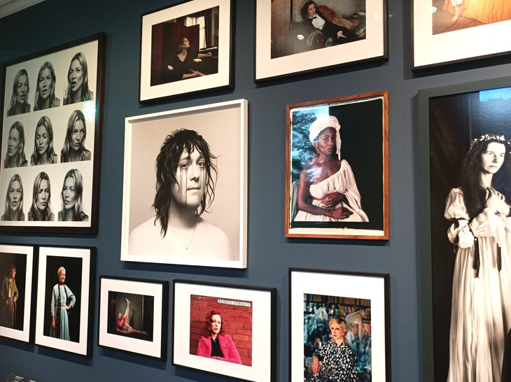 A gallery wall of portraits of women
