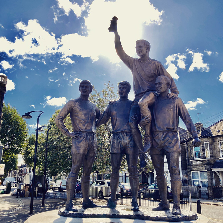 A sculpture showing four World Cup winning footballers holding aloft the Jules Rimet trophy and, in doing so, eclipsing the sun