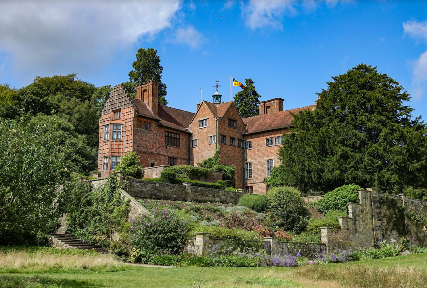 The exterior of Chartwell, a redbrick manor house surrounded by stepped gardens.