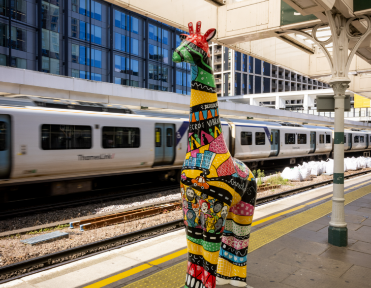 Autumn in London: a colourful painted giraffe sculpture on a platform at East Croydon station.