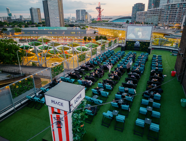 Open air cinema in London: a rooftop cinema at Roof East in Stratford, with The Orbit and other landmarks in the background.