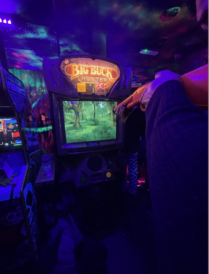 Play arcade games in London: someone holding a gun and playing Big Buck Hunter