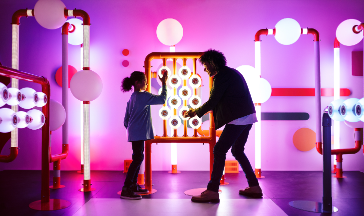 A man and a girl playing with interactive exhibits