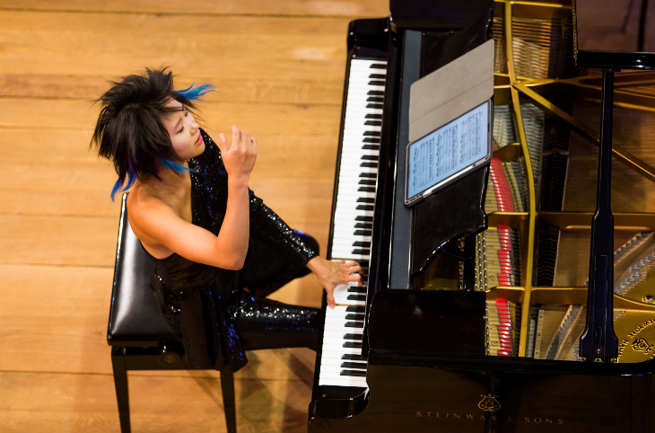 A photo looking down on Yuja Wang playing a piano